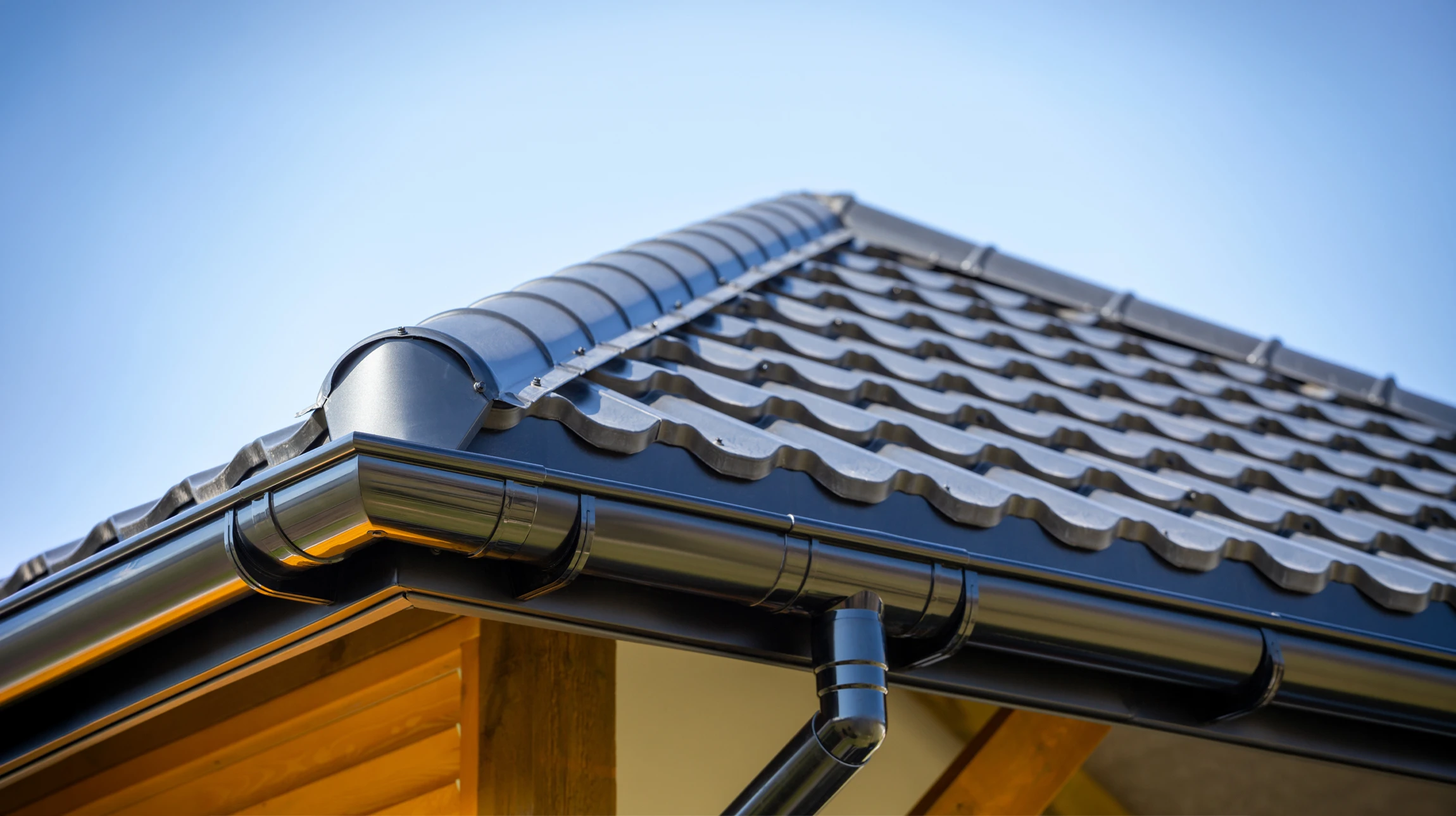 De fortes pluies tombant sur le toit et la gouttière métallique de la maison de briques en été