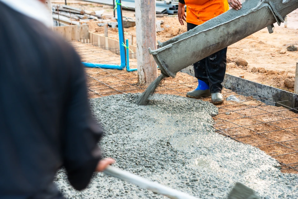 Ouvrier ramoneur &eacute;quip&eacute; d'un h&eacute;risson de ramonage travaillant sur toiture en tuiles m&eacute;caniques rouges, chemin&eacute;e ma&ccedil;onn&eacute;e visible