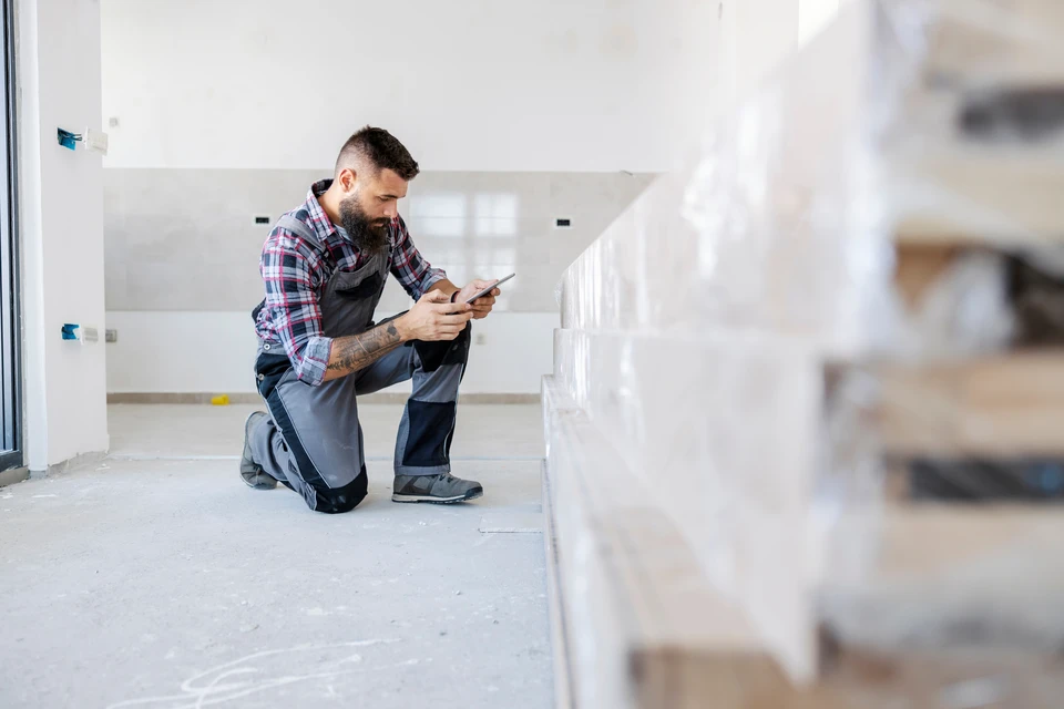 Scène extérieure montrant une clôture en fer forgé ornementale contre un ciel bleu avec végétation en arrière-plan